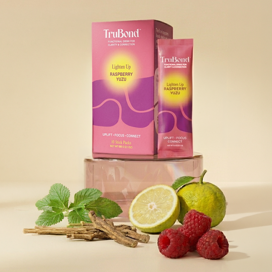 TruBond raspberry yuzu drink packaging with fresh fruits and herbs on a beige background